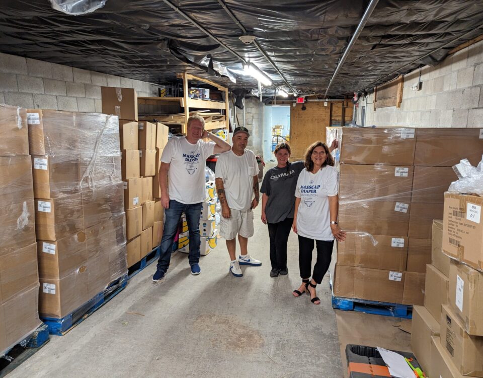 pic of cfc staff with warehouse full of diapers